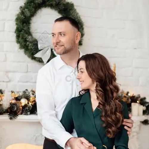 一起庆祝圣诞节穿着节日衣服的年轻夫妇在圣诞树附近拥抱新年情人节