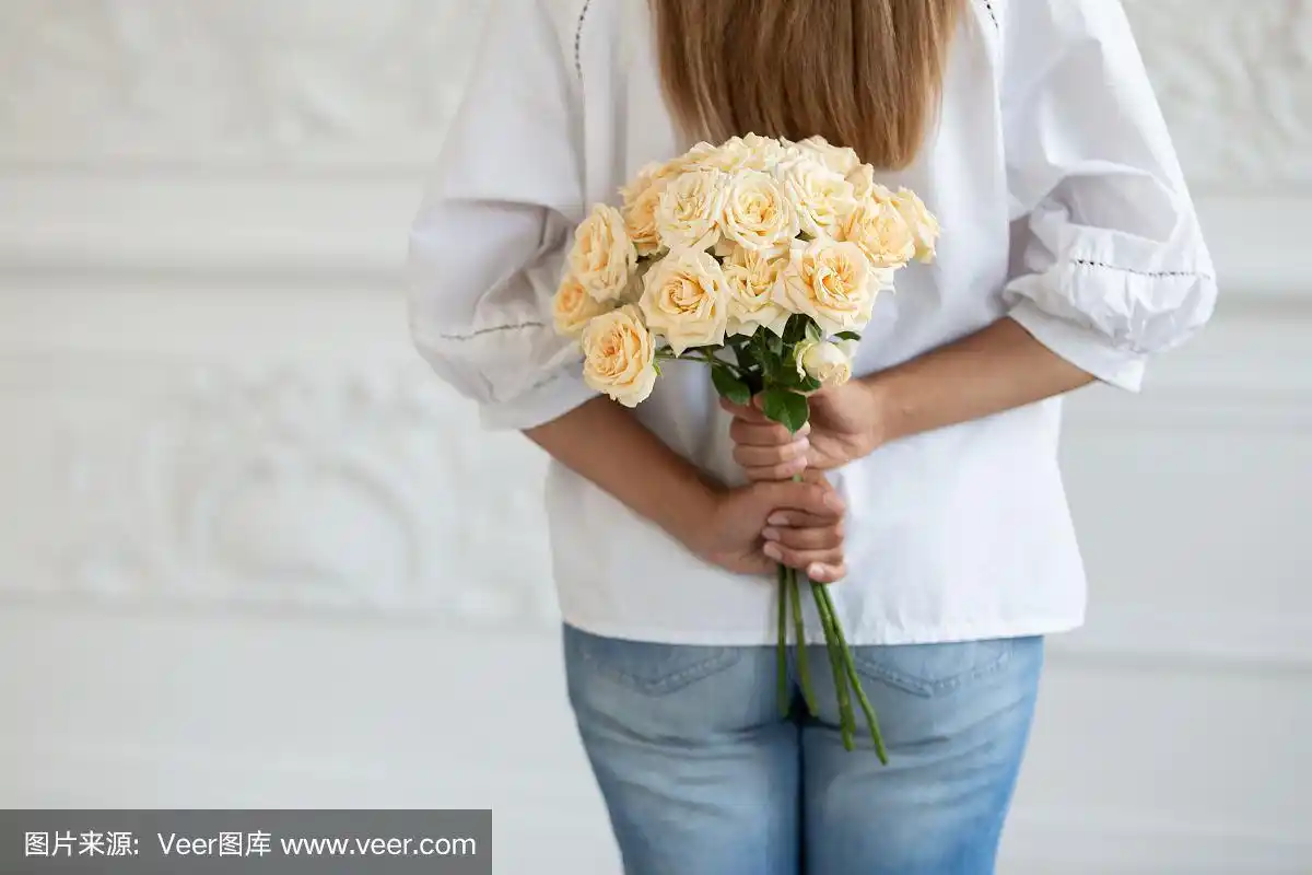 穿白衬衫的女人把一束花藏在背后.有选择性的重点