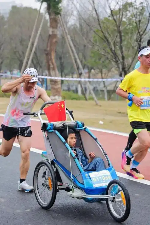 奔跑吧爸爸父亲用轮椅推着14岁脑瘫儿子跑了68场马拉松