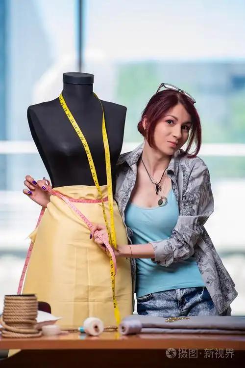 在她的办公桌前工作的女裁缝