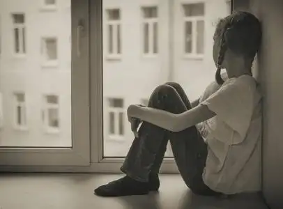 看看忧郁问题可怜的小女孩坐在窗边.黑白照片