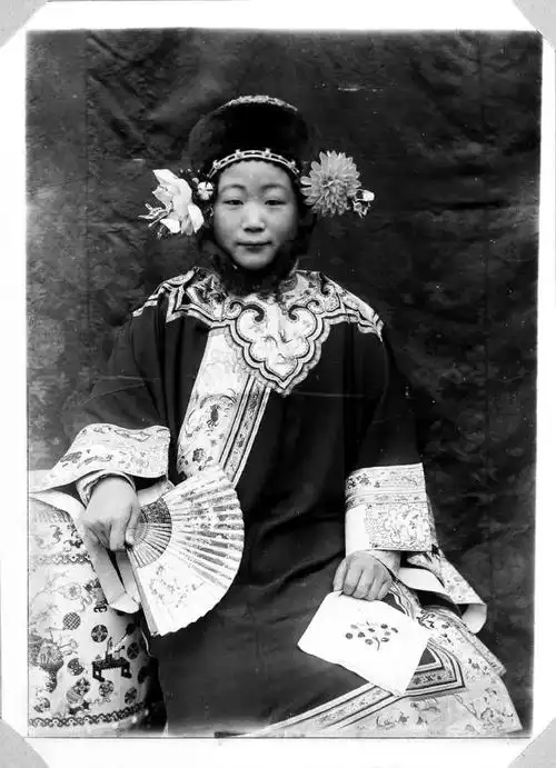 年轻的满族女子,穿夏装,戴冬季头饰.