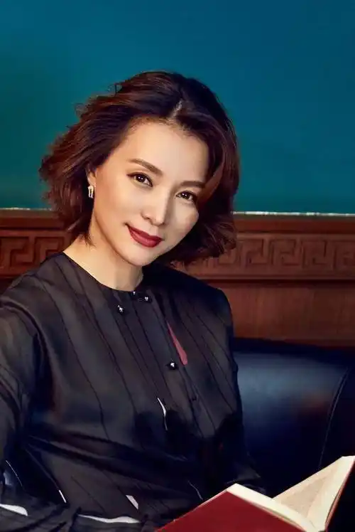 董卿身穿一件白色的衬衫搭配黑色的西服套装,一头微卷的短发所呈现的