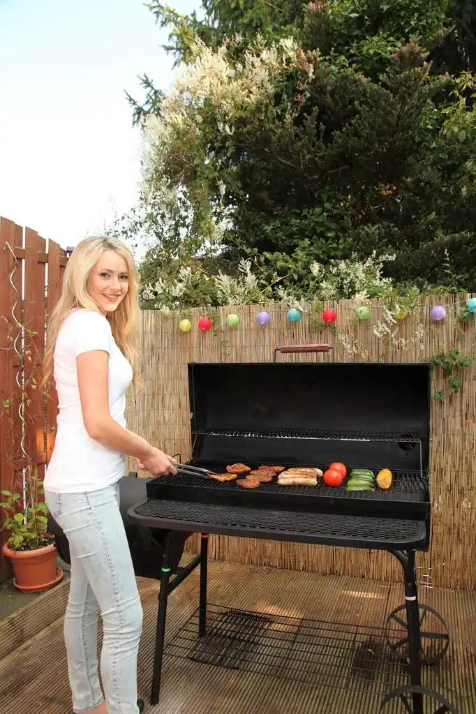 年轻女子在户外烧烤烹饪