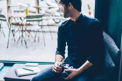 宋姓氏唯美图片沉思的时尚男性摄影师看着窗外休息窗台.