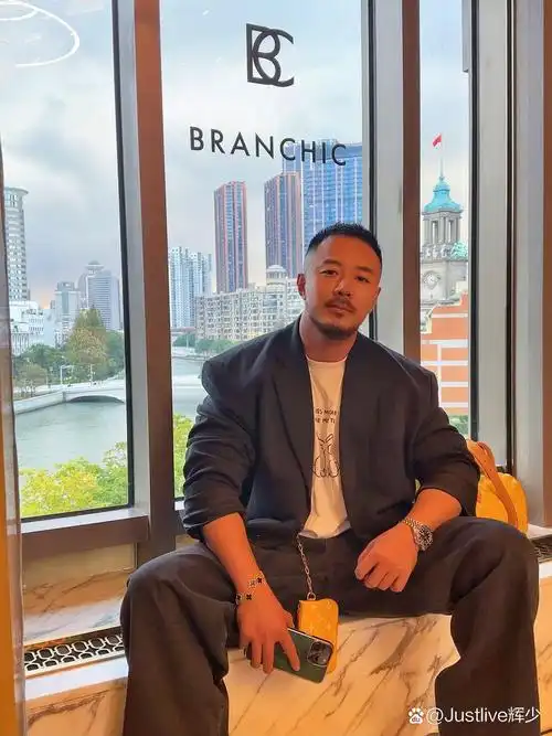 帅气的胡子大叔,坐在窗边,手拿一杯咖啡,刷着手机,享受一个人的宁静