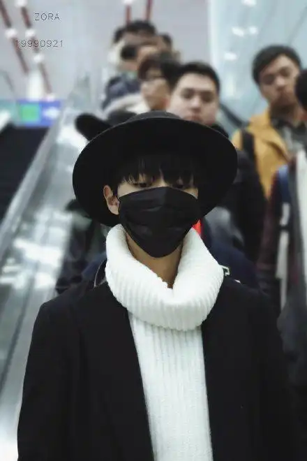 王俊凯在机场全身照,穿黑色呢大衣戴口罩