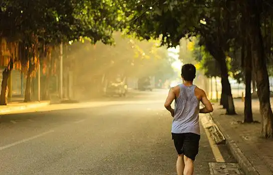 早晨迎着阳光在路上跑步
