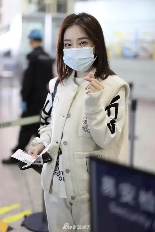 组图:冯提莫白色印花look机场玩小清新 上演歪头杀比心嘟嘴卖萌