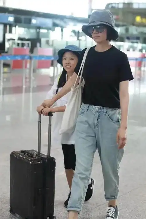 皮肤也有点黑,在之前跟妈妈的机场照中,夏哈哈戴着跟妈妈一样的渔夫帽