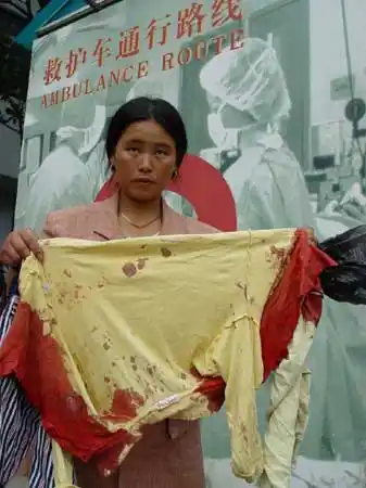 图文受害家长展示小孩被砍时留下的血衣