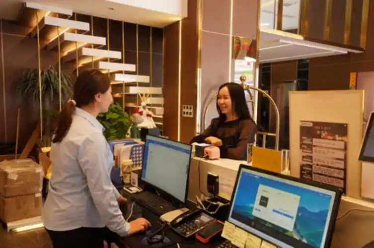 工作人员正热情地为前台预约办理入住手续的游客提供服务.