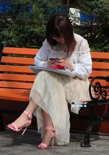 坐在椅子上办公的美女,粉红色的高跟凉鞋非常漂亮