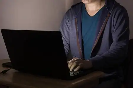 在黑暗中工作或玩笔记本电脑的男性或男性照片