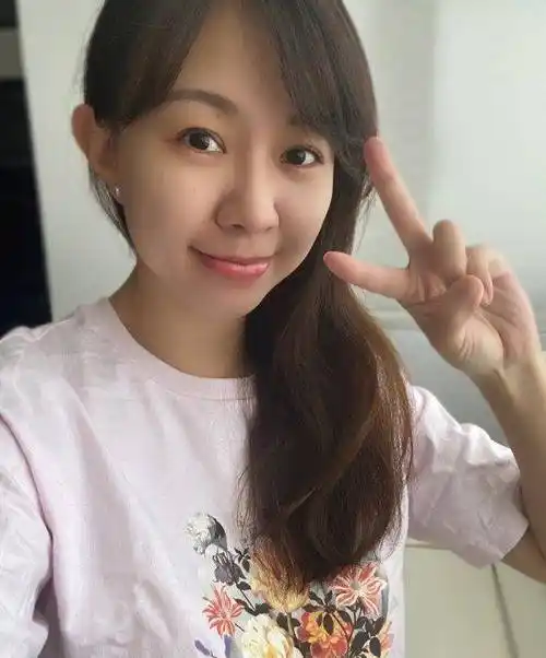 照片中的卓依婷身穿一件淡粉色t恤,还印有鲜艳的花朵,一头柔顺的长发