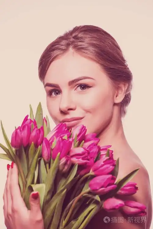 漂亮的女人抱着郁金香花束的特写肖像