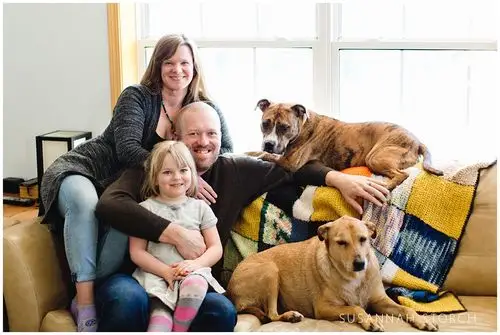 three people and two dogs make up this family portrait