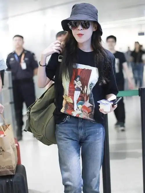 47岁洪欣低调走机场,黑t恤搭配牛仔裤简约清爽,素颜难掩好气质