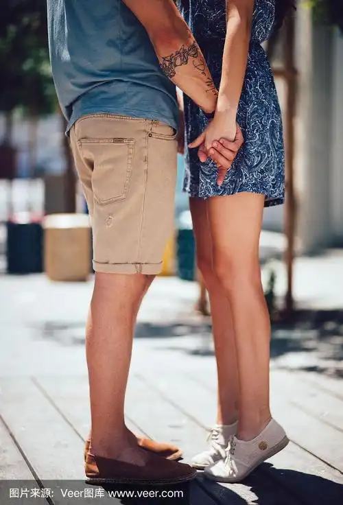 年轻可爱的女友踮着脚尖在户外想要一个吻