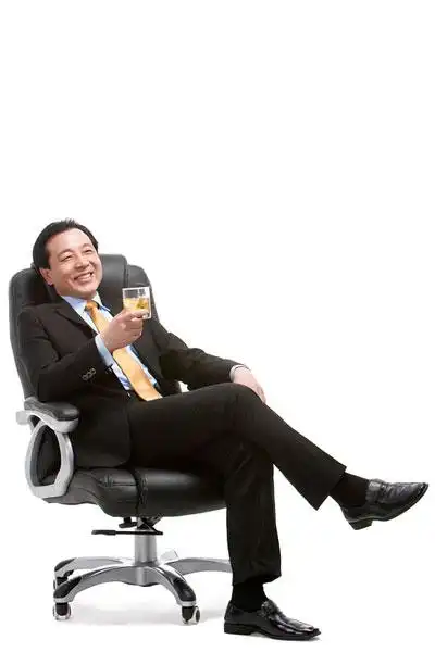 中年商务人士坐在老板椅上喝威士忌