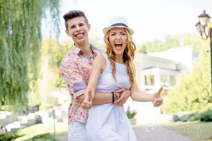 一对年轻漂亮的恋人在一起男人拥抱他的女朋友微笑着