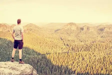 徒步旅行, 在大自然中活动的假期.人在悬崖边看薄雾的风景照片