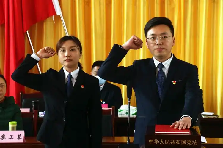 的宗场镇人民政府副镇长谢宗庭(右),郭玉洁(女)(左)向宪法进行宣誓