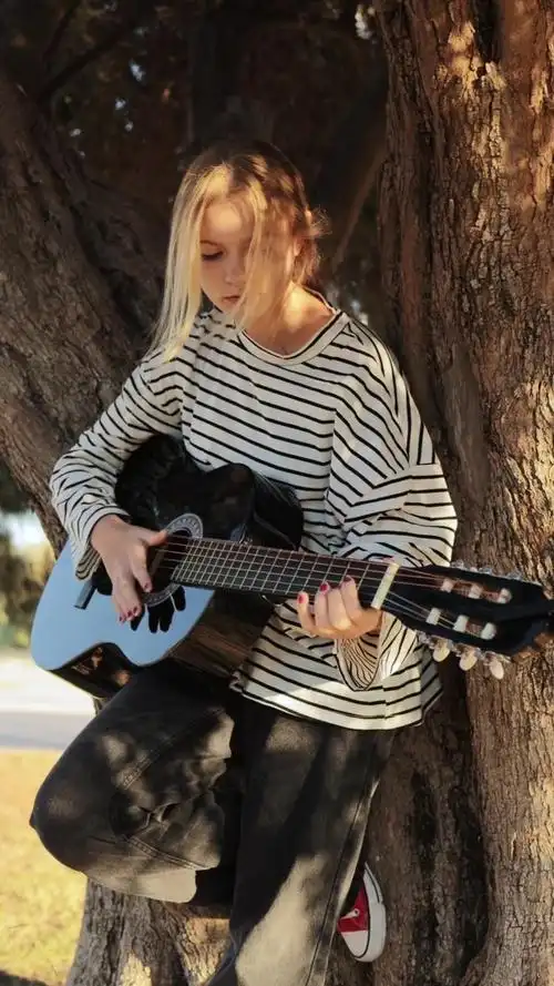 一个来自欧洲的金发女郎在弹吉他.复杂音符的指法.