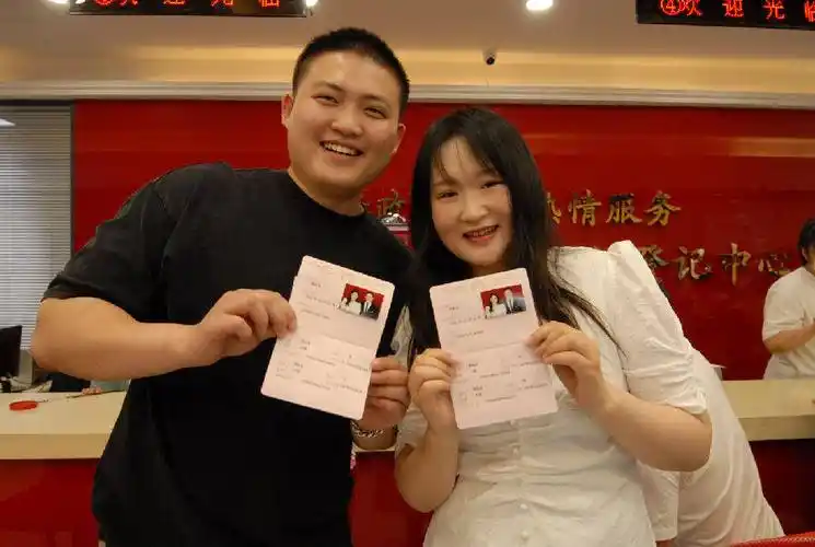 即墨区民政局婚姻登记处一对新人展示刚领到的结婚证(张涛 摄)
