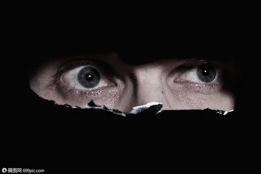 个男人透过墙上的个洞偷看的可怕的眼睛危险狭缝