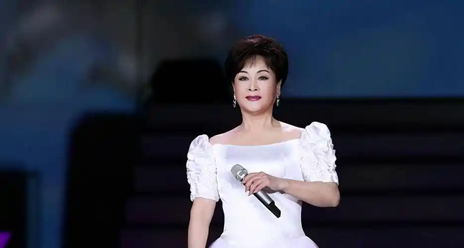 76岁李谷一走机场,穿大花袄踩高跟靴,素颜出镜依然美出新高度_黑色