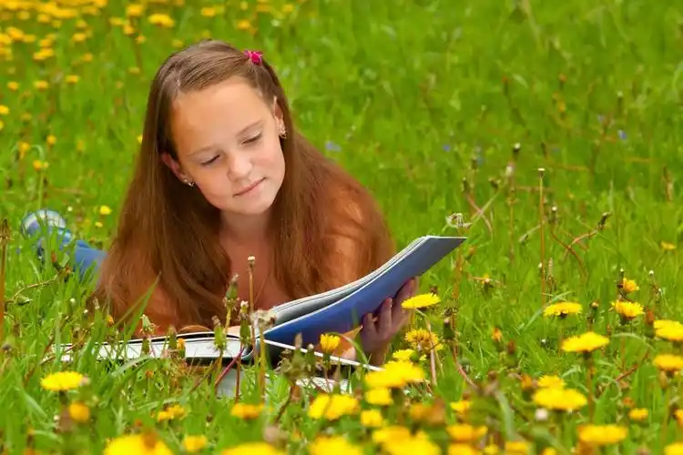 11 岁女孩在草地上读书