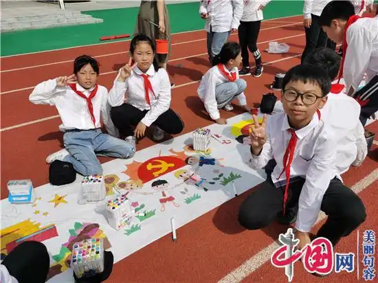 用手中的彩色画笔描绘着对党和国家的赞美之情,其中既有党旗,国旗等