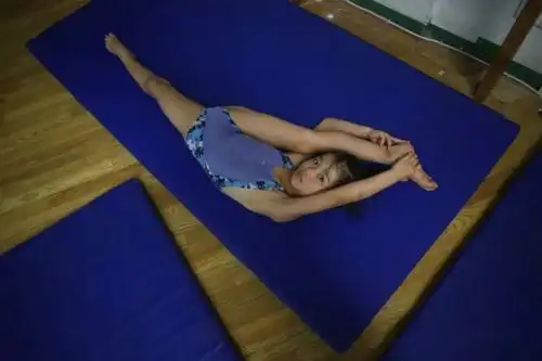 武汉-2016年8月19日,跳水陆上训练房内,一名六岁的孩子在压腿.