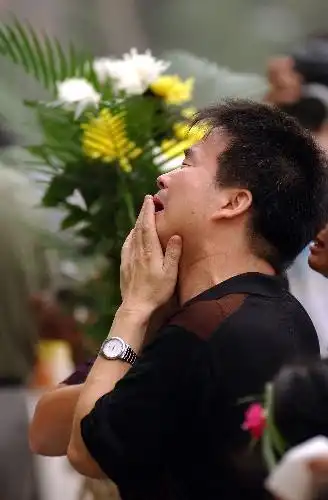 7月28日,一名悼念者在唐山地震纪念墙前哭泣.新华社记者杨世尧摄