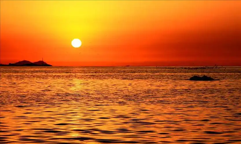 日出日落的太阳是橙红色的正午的太阳是黄白色的这是为什么