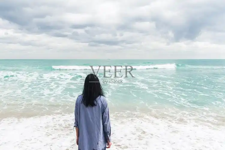 在海滩上看海的女人照片摄影图片