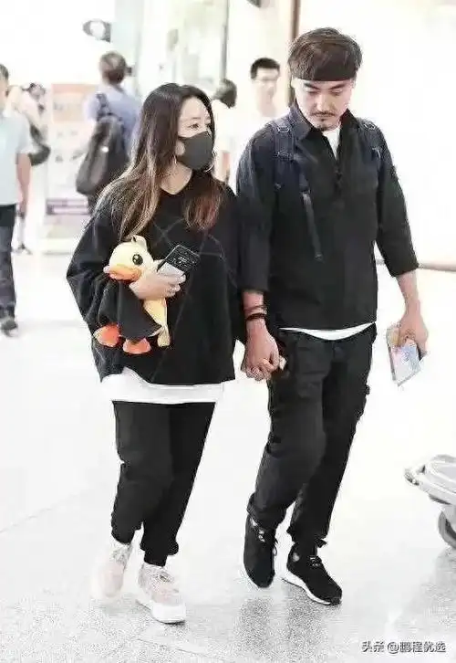 何洁带二婚老公走机场穿成小矮人还臃肿老公锅盖头更夸张