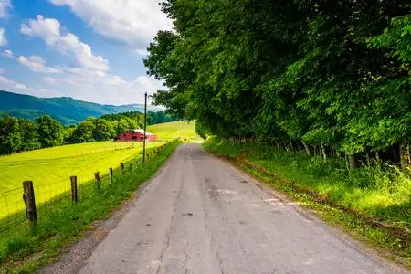 谷仓和沿着一条乡间小路在农村的波托马克河 highla 字段照片