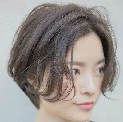 这位梳偏分波波头短卷发的女孩子,将头发全部染成亚麻咖啡色,低调的发