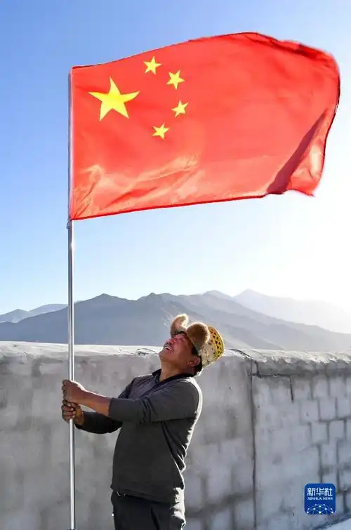 在湘河水库移民新村,搬迁群众罗布占堆在新居屋顶竖起五星红旗(3月