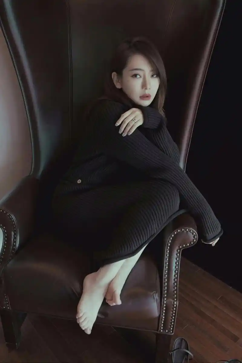 棕色皮沙发 黑色高跟鞋和地板 再这样一个暗色调的环境里 戚薇的皮肤