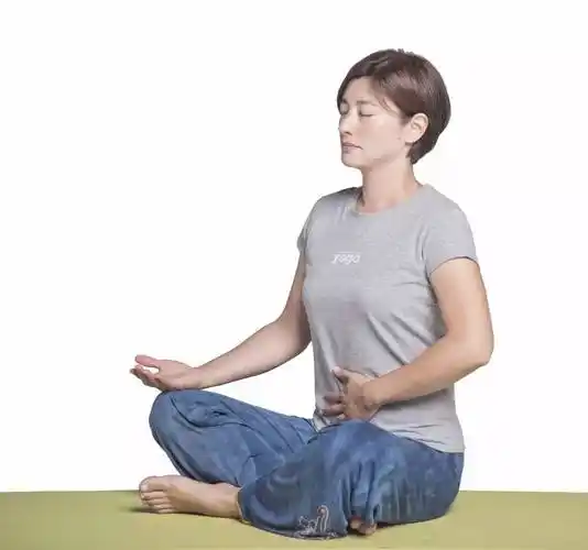 盘腿坐,一手置于膝盖,一手放在腹部.