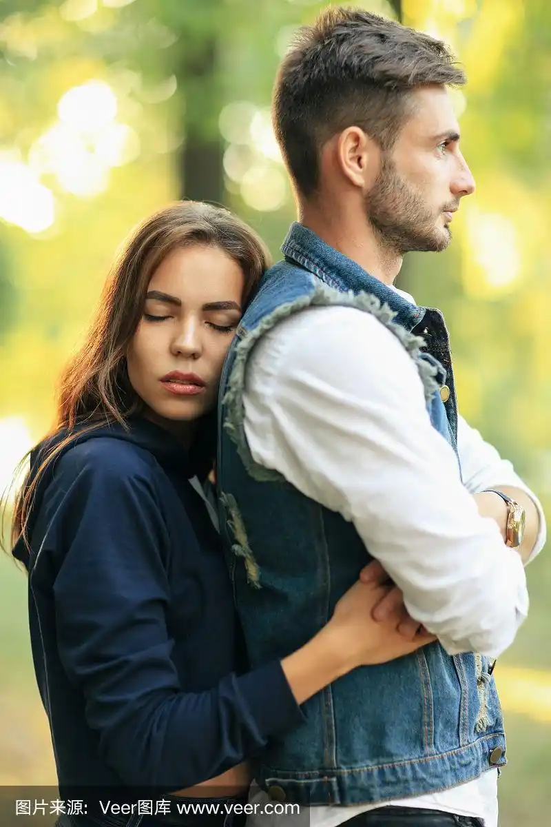 侧面的年轻女子与紧闭的眼睛拥抱的男友