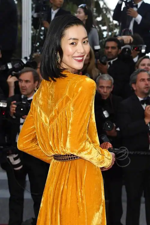 刘雯亮相戛纳红毯,身穿橘色丝绒长裙,隐约露出黑色内衣