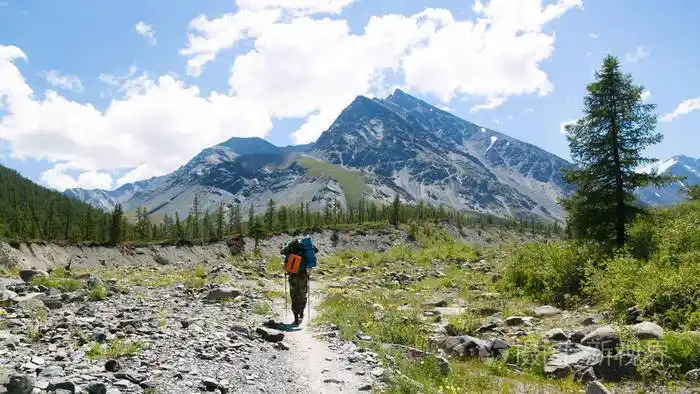 这位游客去了一座遥远的高山.一个背着背包的男人在山上旅行