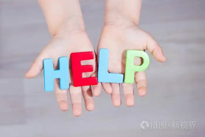 孩子请求帮助.手掌上的书面的帮助字母