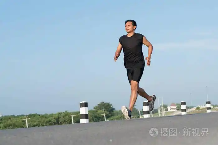 亚洲年轻人奔跑在时间在日出期间在水坝路锻炼.健康的生活方式