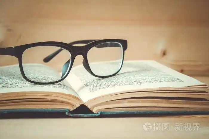 旧的书和眼镜与滤波效果复古木制的桌子上