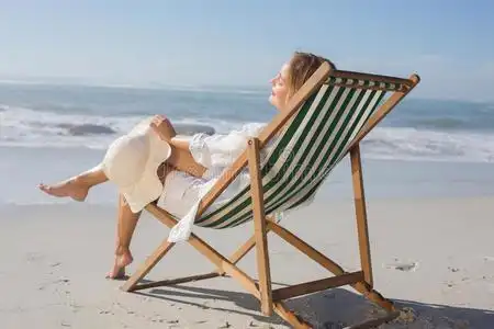 在海边躺椅上休息的女人照片